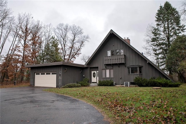 view of front of property with central AC unit, a garage, and a front lawn