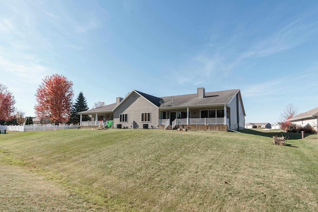 back of property with a yard and a porch