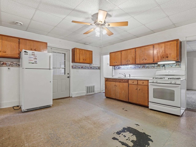 kitchen with a paneled ceiling, white appliances, sink, ceiling fan, and decorative backsplash