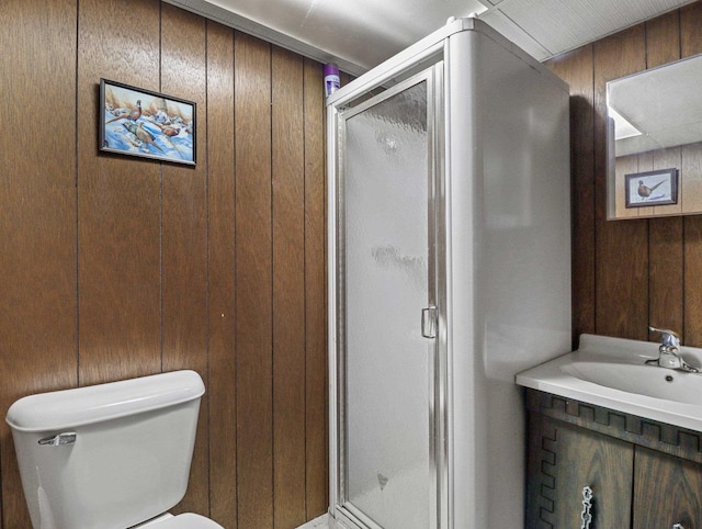 bathroom featuring vanity, wood walls, toilet, and walk in shower