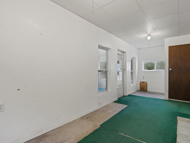 interior space featuring a drop ceiling and concrete floors