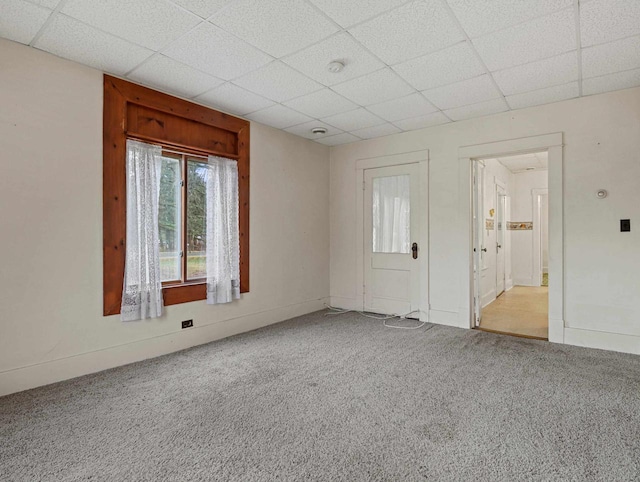 unfurnished room with a paneled ceiling and light carpet