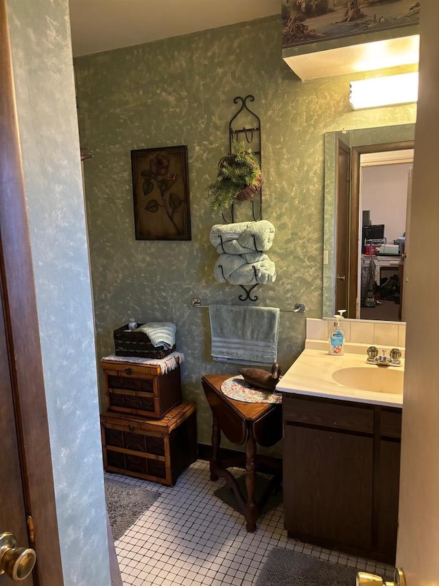 bathroom featuring tile patterned flooring, vanity, and wallpapered walls