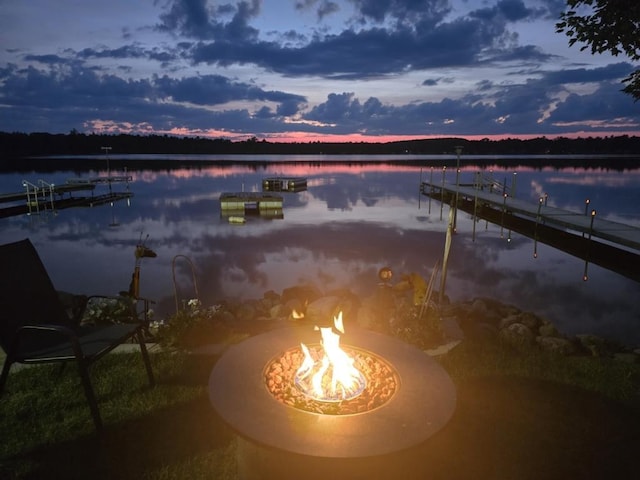 dock area with a fire pit and a water view