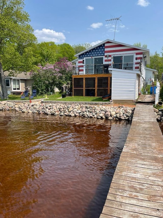 view of dock featuring a water view and a balcony