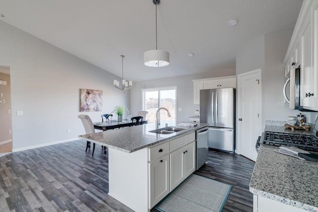 kitchen with a center island with sink, stainless steel appliances, vaulted ceiling, white cabinets, and sink