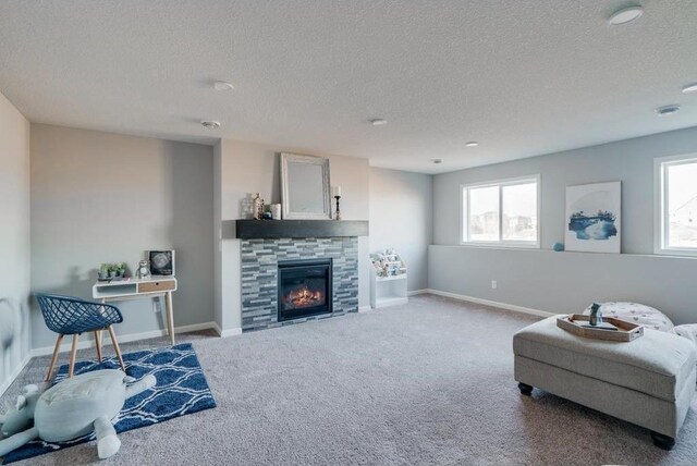 carpeted living room featuring a textured ceiling and a tile fireplace