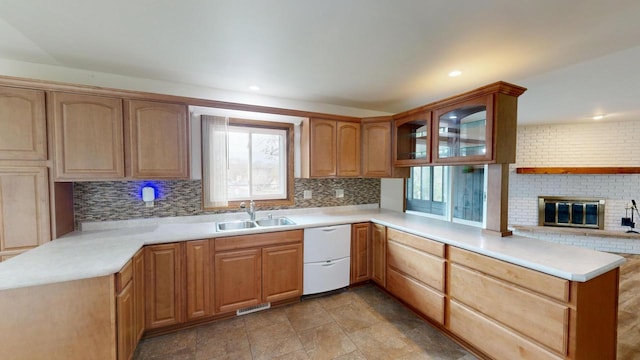 kitchen featuring dishwasher, kitchen peninsula, sink, and a wealth of natural light