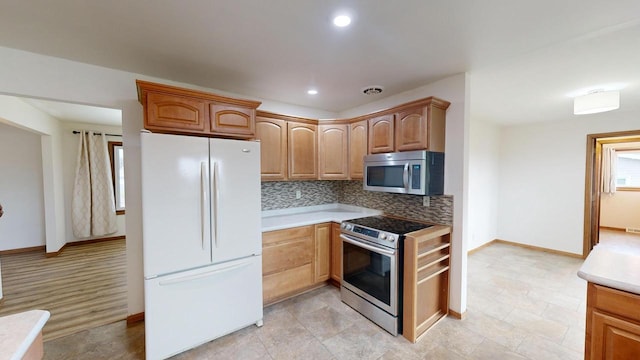 kitchen with stainless steel appliances and tasteful backsplash