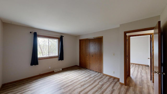 unfurnished bedroom featuring a closet and light hardwood / wood-style floors