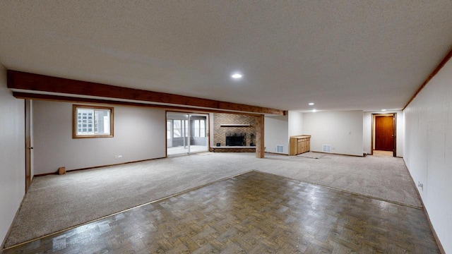 unfurnished living room featuring a fireplace, parquet floors, and a textured ceiling