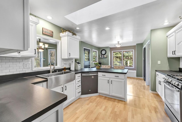 kitchen featuring kitchen peninsula, white cabinetry, light hardwood / wood-style floors, and appliances with stainless steel finishes