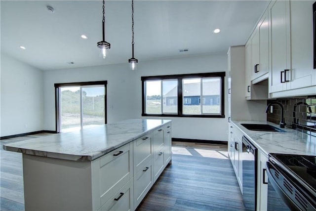 kitchen with sink, white cabinets, hanging light fixtures, and a kitchen island