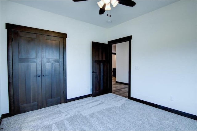 unfurnished bedroom with dark colored carpet, a closet, and ceiling fan