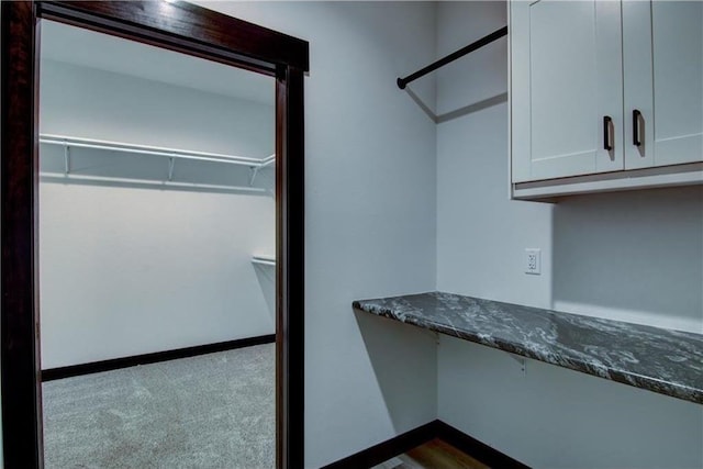 walk in closet featuring dark colored carpet