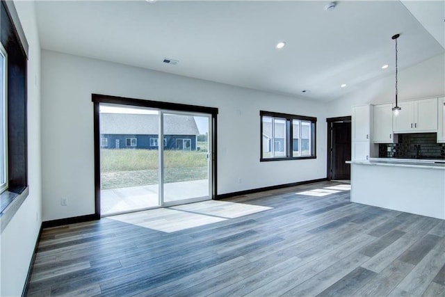 kitchen featuring white cabinetry, dark hardwood / wood-style flooring, decorative light fixtures, and lofted ceiling