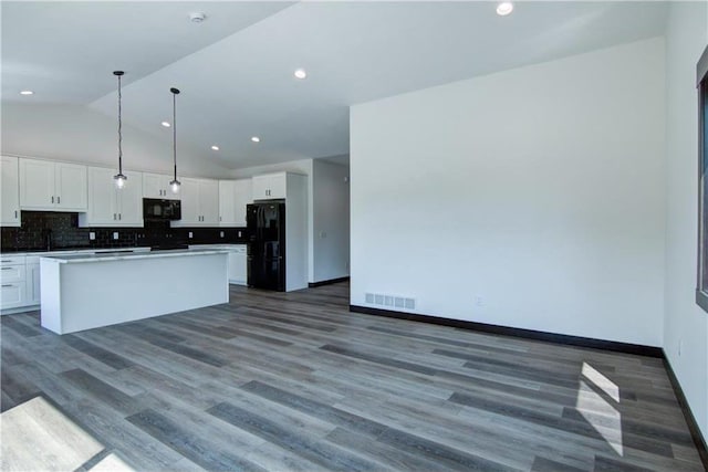 kitchen with white cabinetry, dark wood-type flooring, black appliances, and vaulted ceiling