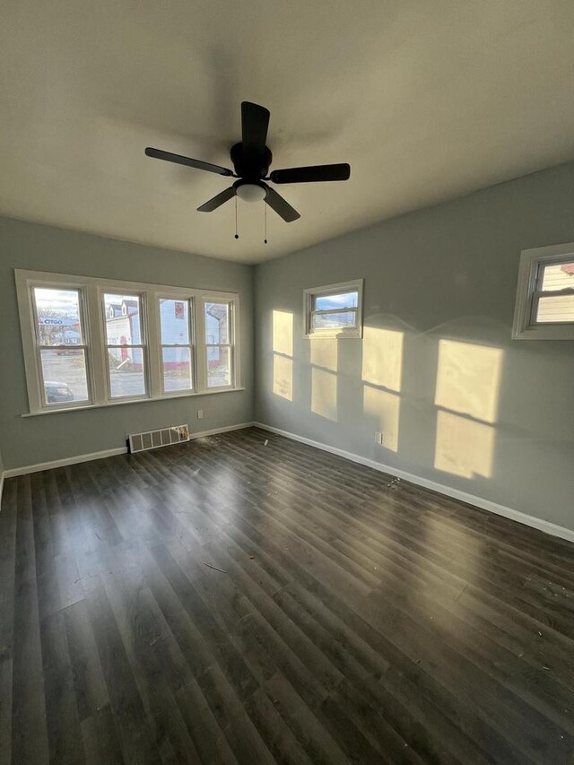 unfurnished room featuring ceiling fan and dark wood-type flooring