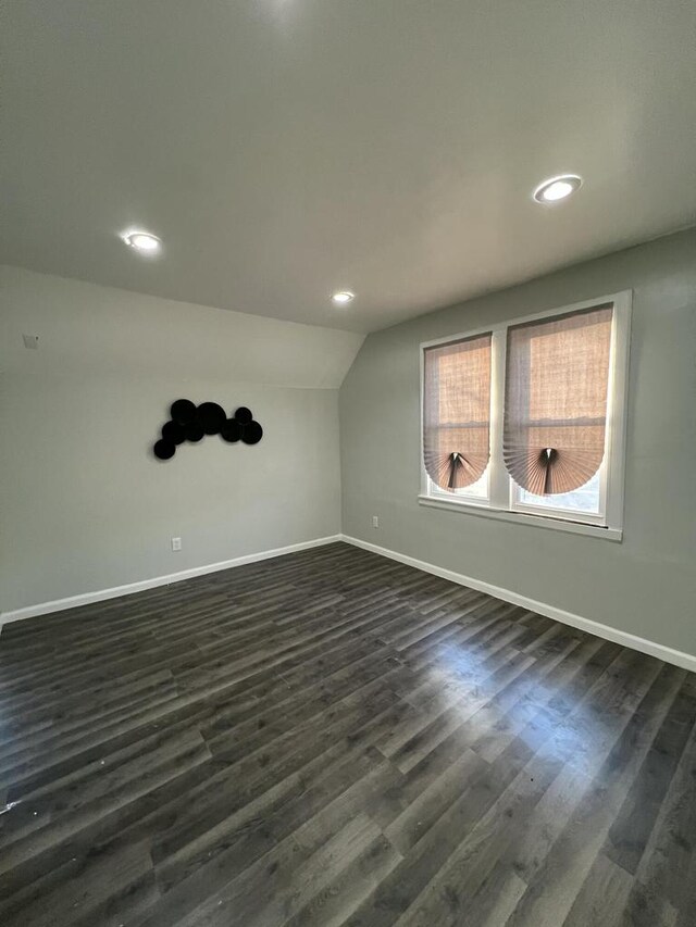 spare room with lofted ceiling and dark hardwood / wood-style floors
