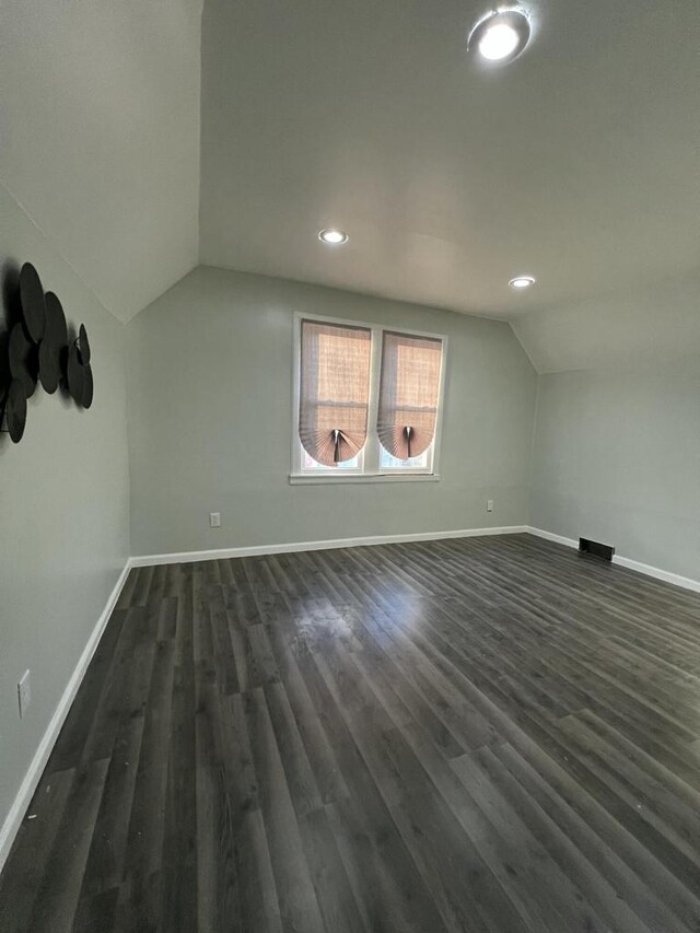 additional living space featuring lofted ceiling and dark hardwood / wood-style floors