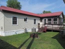 rear view of house featuring a wooden deck and a yard