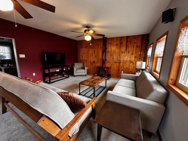 living room with plenty of natural light, wood walls, and ceiling fan