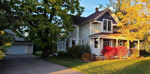 view of front of home featuring a garage, an outbuilding, and a front yard