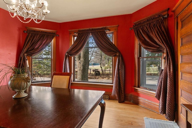 2730 Chestnut Dr, Plover, WI 54467 - unfurnished dining area with light wood-type flooring, a chandelier, and baseboards