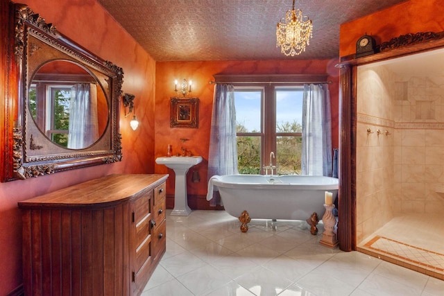 2730 Chestnut Dr, Plover, WI 54467 - bathroom featuring tile patterned flooring, a chandelier, a freestanding tub, a sink, and tiled shower
