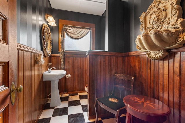 2730 Chestnut Dr, Plover, WI 54467 - half bathroom with tile patterned floors, wood walls, a wainscoted wall, toilet, and a sink