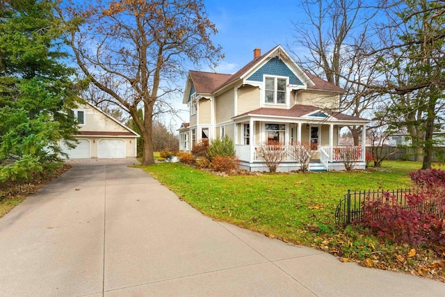 2730 Chestnut Dr, Plover, WI 54467 - victorian house with a porch, an outdoor structure, a chimney, and a detached garage