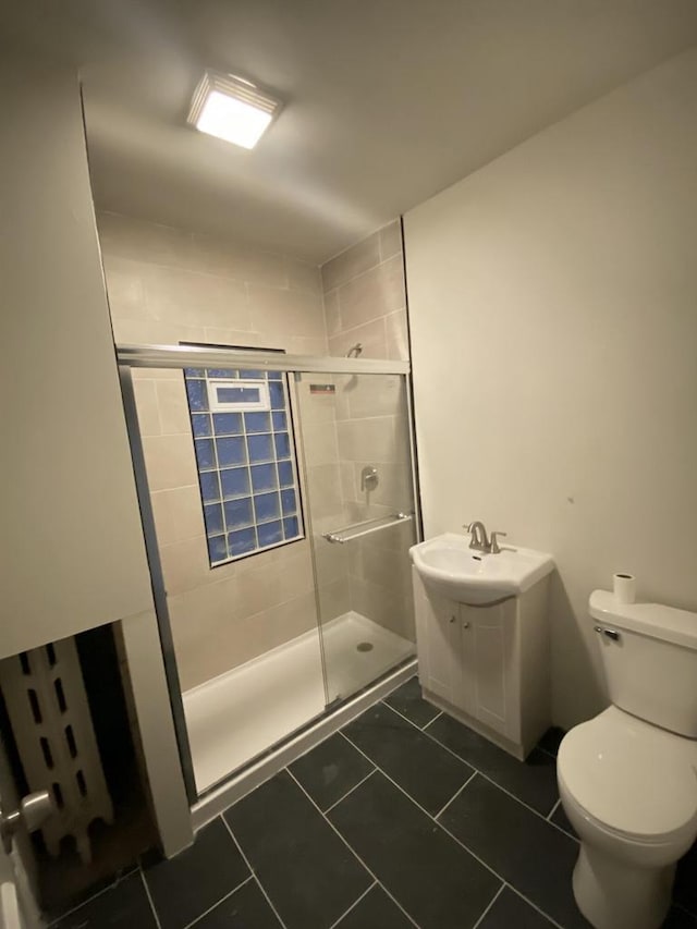 full bathroom with a shower stall, tile patterned flooring, toilet, and vanity