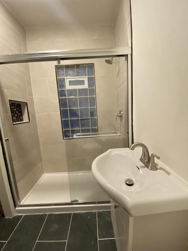 bathroom with a stall shower and tile patterned floors