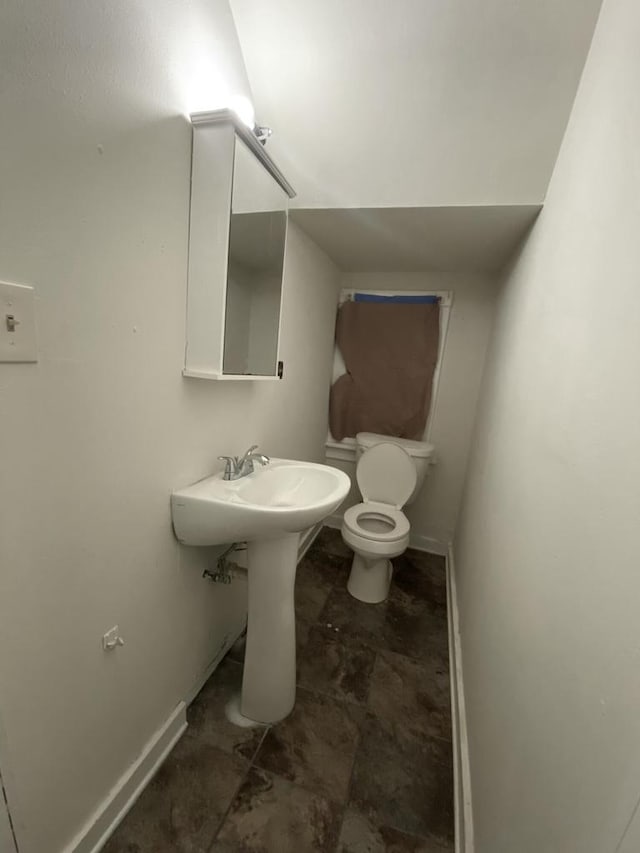 bathroom featuring toilet and baseboards