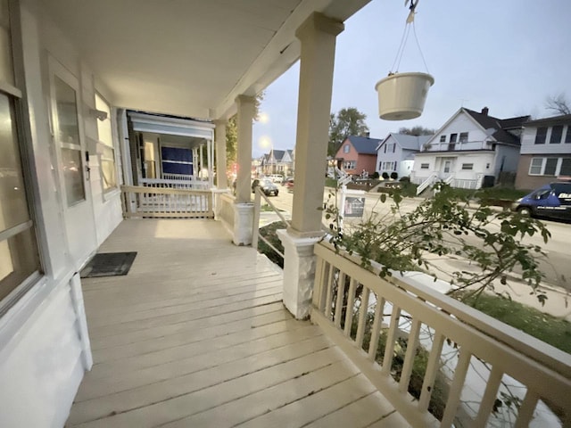 wooden terrace with a porch and a residential view