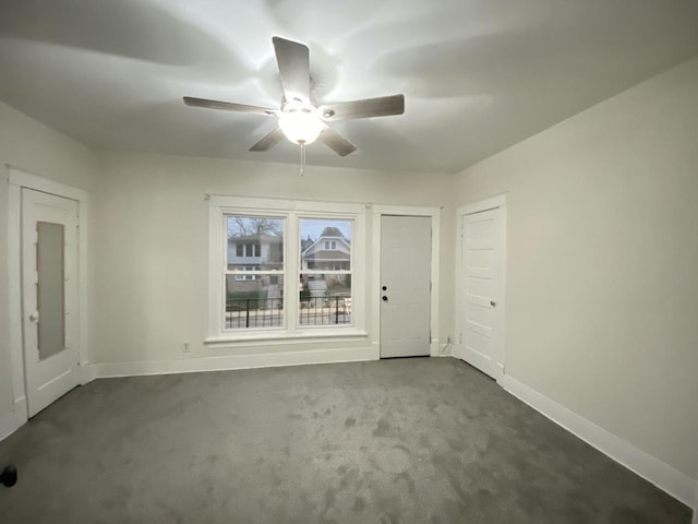 spare room with carpet, ceiling fan, and baseboards