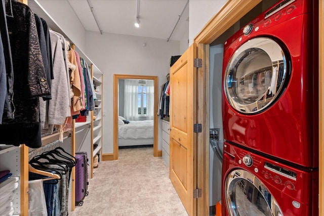 washroom featuring stacked washer / drying machine and light colored carpet