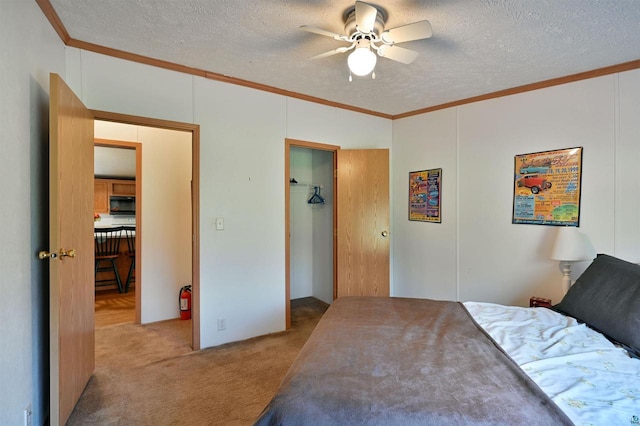 bedroom with light carpet, crown molding, ceiling fan, a textured ceiling, and a closet