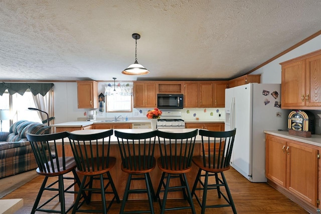 11242 S Pierce Rd, Solon Springs, WI 54873 - kitchen featuring white appliances, wood finished floors, a textured ceiling, a kitchen island, and a kitchen bar