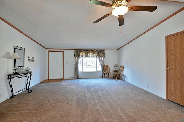 interior space featuring carpet, ceiling fan, crown molding, and a textured ceiling