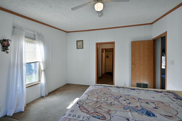 carpeted bedroom with a textured ceiling, ceiling fan, and ornamental molding