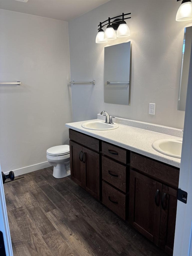 bathroom with vanity, hardwood / wood-style flooring, and toilet