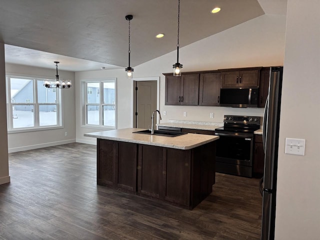 kitchen with sink, appliances with stainless steel finishes, dark brown cabinets, an island with sink, and decorative light fixtures