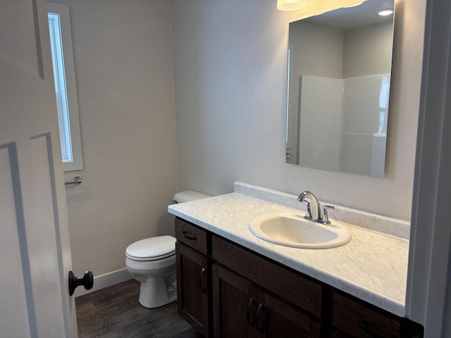 bathroom featuring a shower, hardwood / wood-style floors, vanity, and toilet