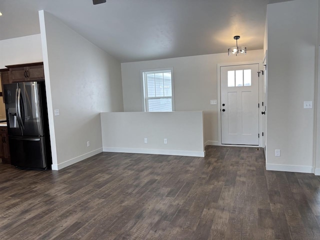 foyer entrance with lofted ceiling, a chandelier, dark hardwood / wood-style floors, and a healthy amount of sunlight