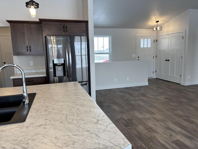 kitchen featuring dark wood-type flooring, dark brown cabinetry, sink, stainless steel fridge, and pendant lighting