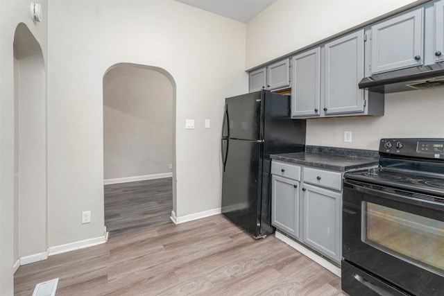 kitchen featuring light wood-type flooring, gray cabinetry, and black appliances