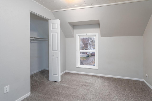 unfurnished bedroom with carpet, vaulted ceiling, and a closet