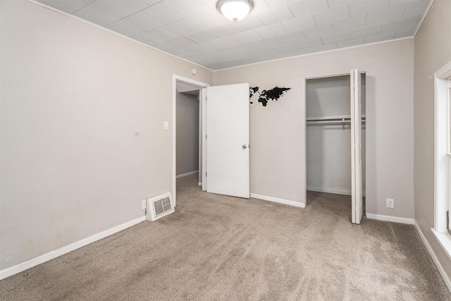 unfurnished bedroom featuring light colored carpet, a closet, and ornamental molding