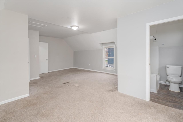 bonus room featuring light colored carpet and vaulted ceiling